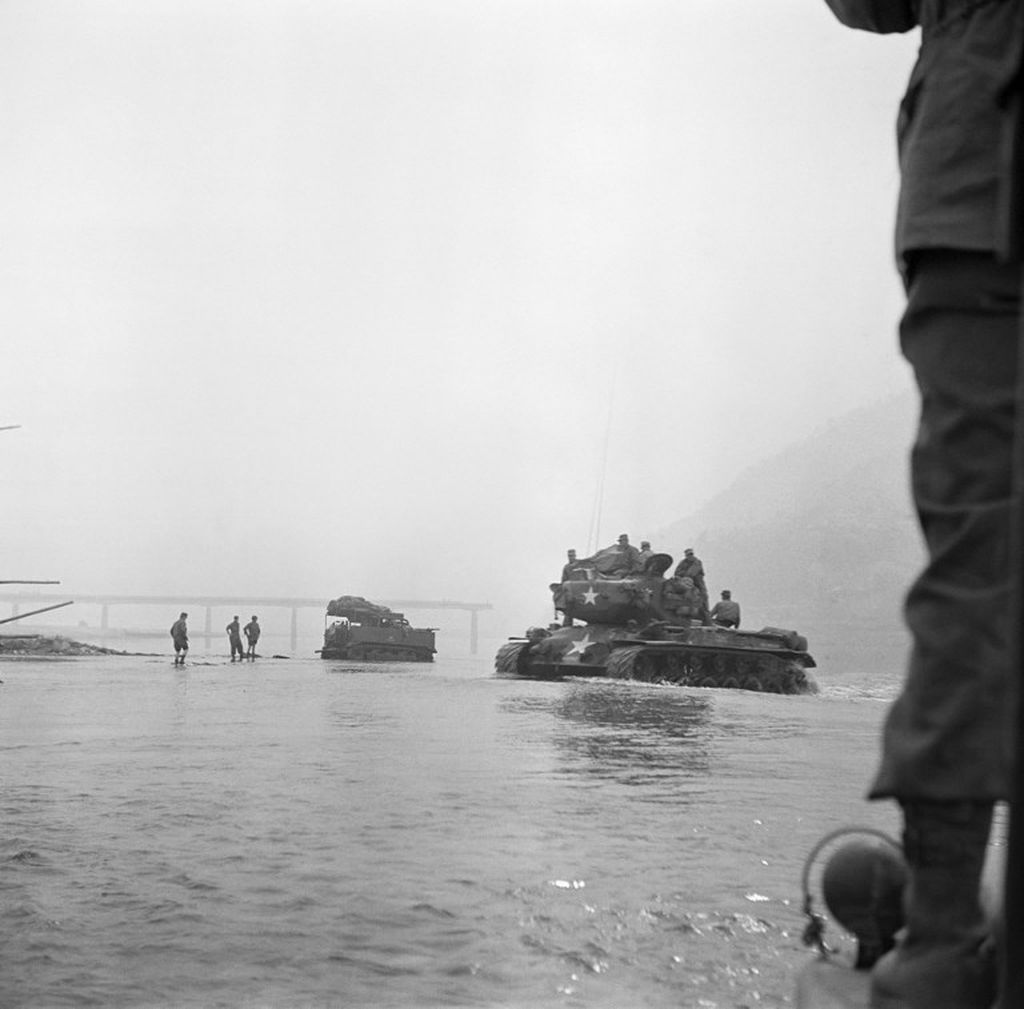 Truk dan tank PBB menyeberangi sungai di Korea Selatan pada April 1951 selama Perang Korea.  