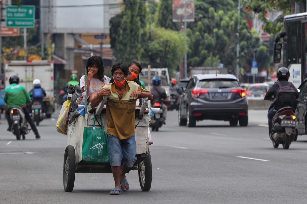 Sebuah keluarga pemulung menyusuri Jalan Juanda, Gambir, Jakarta Pusat, saat memulung, Jumat (6/8/2021). Pandemi Covid-19 telah menyebabkan tingkat kemiskinan di Indonesia bertambah. Berdasar data Badan Pusat Statistik, angka kemiskinan pada Maret 2021 mencapai 27,54 juta orang (10,14 persen jumlah penduduk) atau meningkat 1,12 juta orang dibandingkan dengan Maret 2020. 