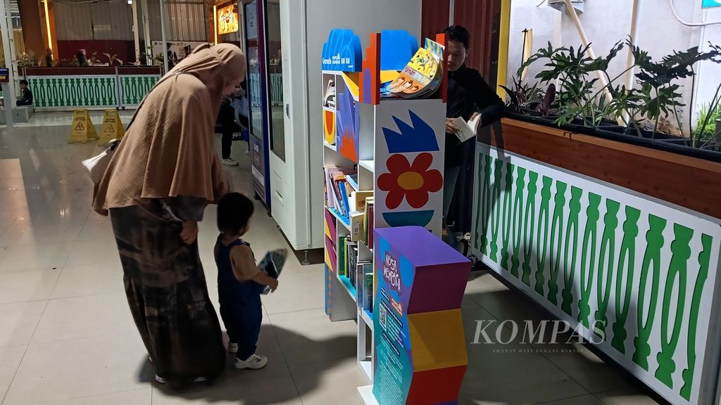 Seorang ibu menemani anaknya memilih buku di perpustakaan mini Gramedia Stasiun Besar Bogor, Kota Bogor, Jawa Barat, Sabtu (2/3/2024).