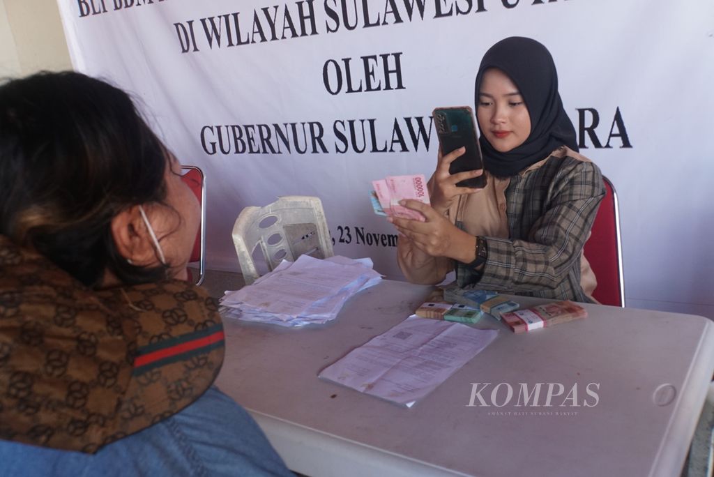 Petugas mengambil foto penerima bantuan subsidi upah di Kantor Pos Manado, Sulawesi Utara, Senin (28/11/2022). Setiap orang dengan upah di bawah Rp 3,5 juta menerima Rp 600.000.