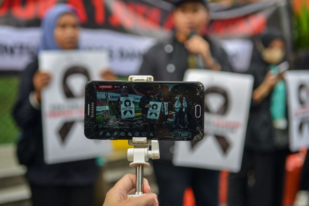 Seorang wartawan menyiarkan langsung aksi di kawasan Jalan Jenderal Sudirman, Jakarta Pusat, Jumat (31/3/2023). 