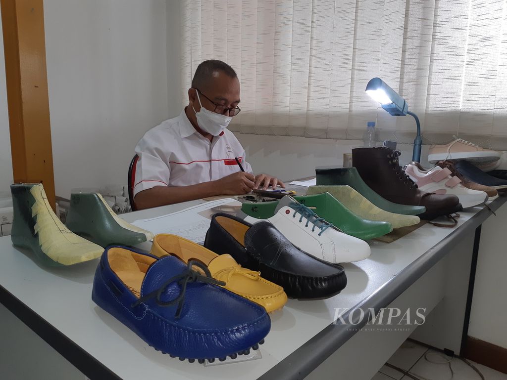 Sejumlah produk PT Sepatu Mas Idaman dipajang dekat pegawai yang sedang bekerja di Bogor, Jawa Barat, Rabu (2/2/2022).