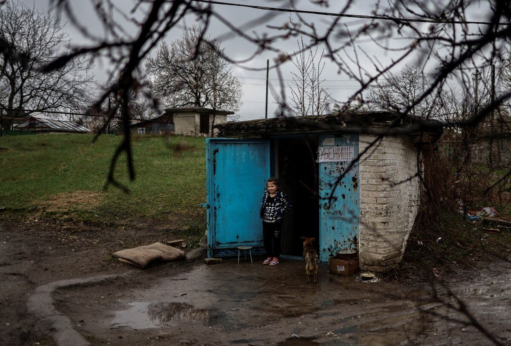 Seorang bocah berdiri di depan bungker di Severodonetsk, wilaya Donbas, Ukraina timur, 13 April 2022, saat pasukan Rusia mengintensifkan serangan untuk merebut wilayah tersebut. 