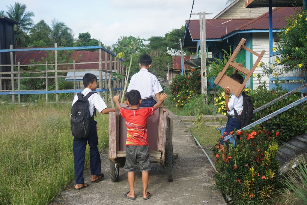 Siswa SMPN 01 Satu Atap Peso mengangkut kursi dan meja sebelum memulai pelajaran di Desa Long Peleban, Kecamatan Peso, Kabupaten Bulungan, Kalimantan Utara, Senin (23/10/2023).