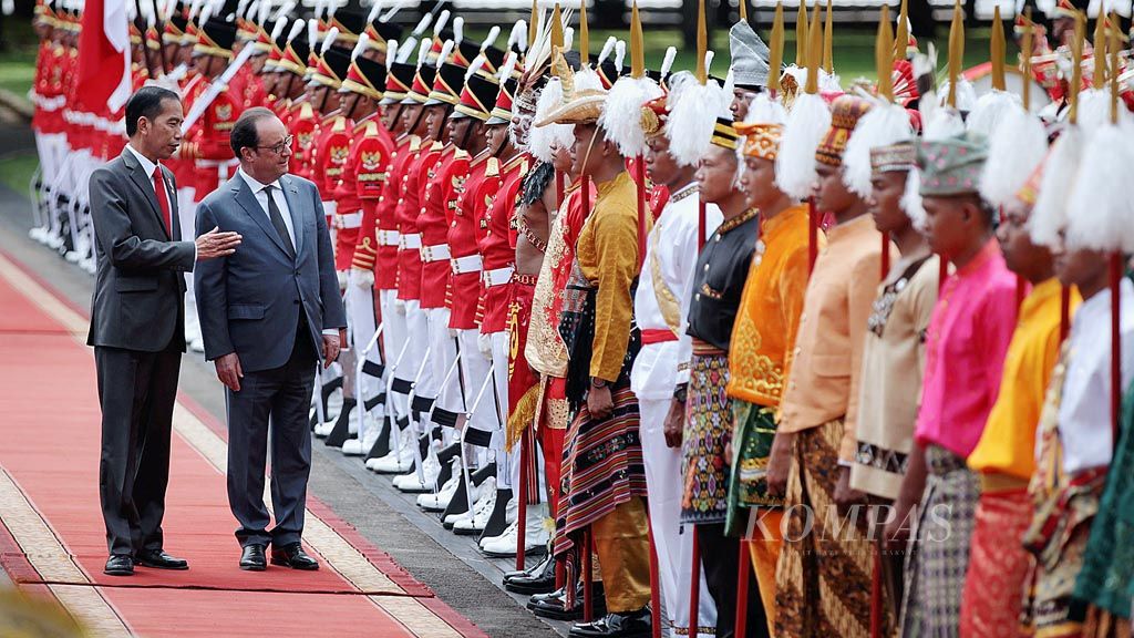 Presiden Joko Widodo (kiri) mendampingi Presiden Perancis Francois Hollande memeriksa pasukan kehormatan saat upacara penyambutan tamu negara di Istana Merdeka, Jakarta, Rabu (29/3). Dalam kunjungan itu ditandatangani lima  naskah kerja sama dalam beberapa bidang. 