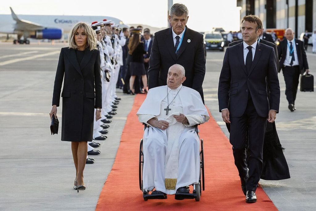 Presiden Perancis Emmanuel Macron (kanan) menyambut Paus Fransiskus di Bandara Marseille, Perancis, Sabtu (23/9/2023). Dalam lawatan ke Marseille, Paus antara lain membahas soal pengungsi.