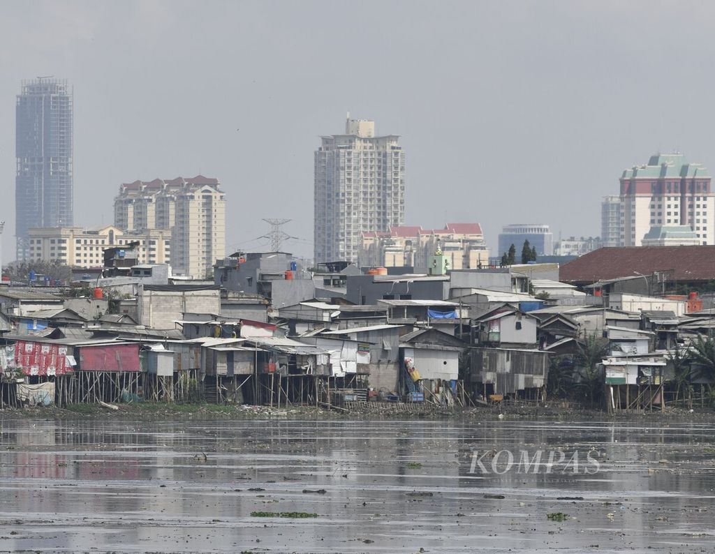 Hunian semipermanen yang digunakan sebagai tempat tinggal warga di kawasan Waduk Pluit, Jakarta Utara, Senin (15/2/2021). 