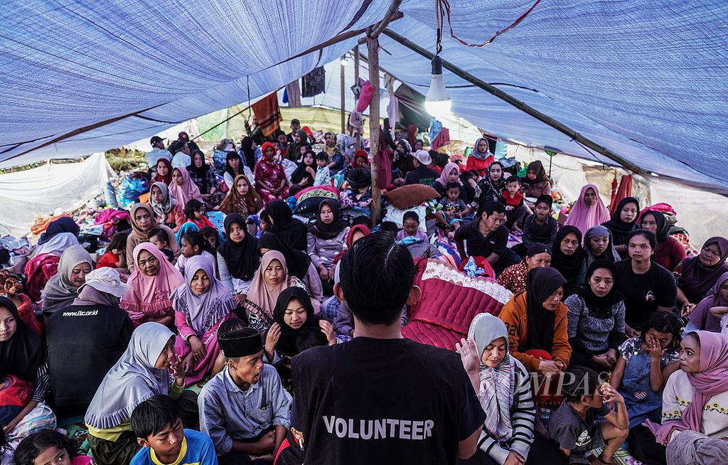 Suasana saat relawan dari Dompet Dhuafa memberikan pelayanan penanganan awal psikologis (Psychology First Aid) bagi para korban gempa di tenda pengungsian RT 005 RW 004 Kampung Panyaweuyan, Pacet, Kabupaten Cianjur, Jawa Barat, Jumat (25/11/2022).
