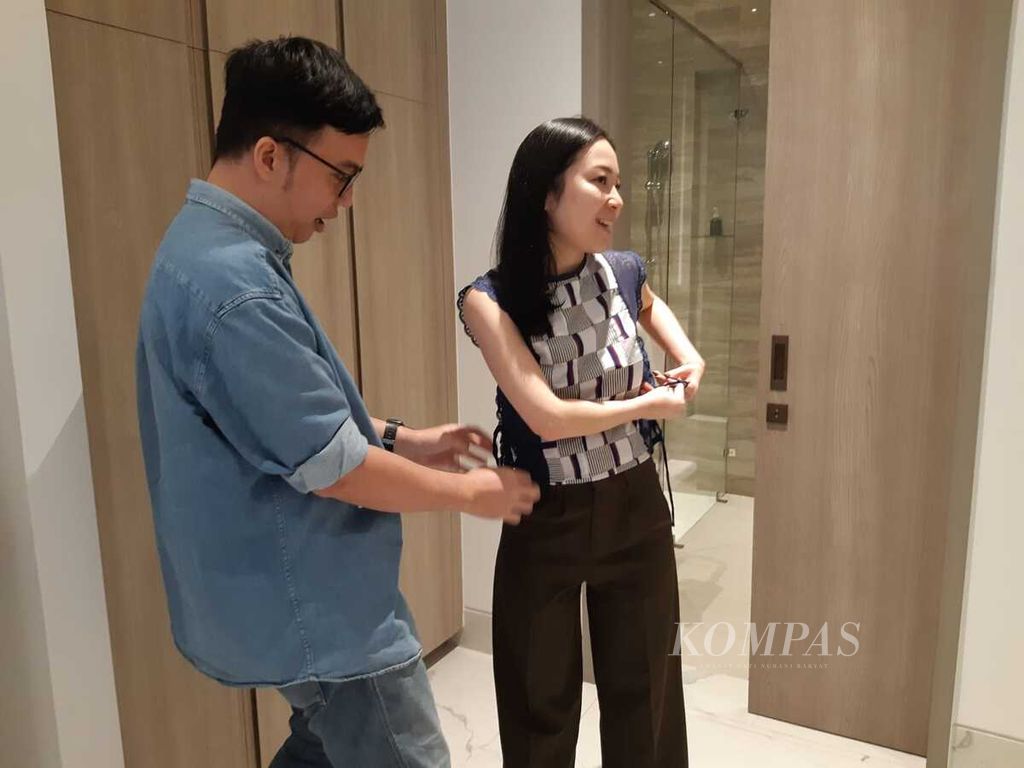 Desainer Adrie Basuki (kiri) sedang memberi saran pemakaian baju karyanya kepada Cindy Handojo, salah satu pelanggannya, pada Private Viewing Raya 2024 yang ia adakan di The Grand Mansion Menteng, Jakarta, 28-29 Maret 2024.