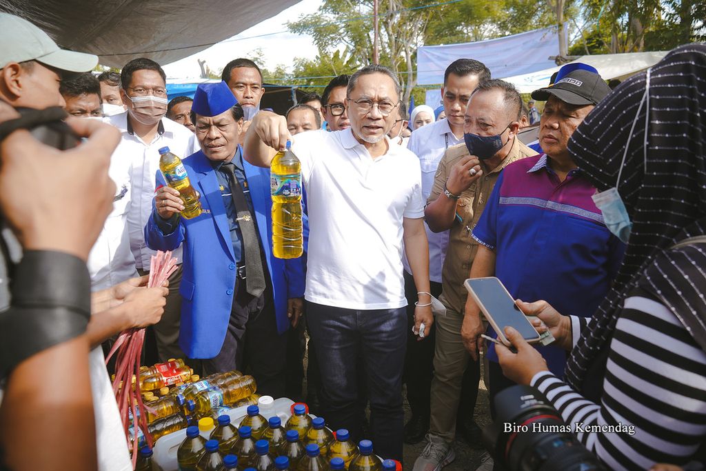 Menteri Perdagangan Zulkifli Hasan menunjukkan minyak goreng curah yang dijual menggunakan kemasan botol bekas air mineral saat berkunjung ke Pasar Toaya, Kabupaten Donggala, Sulawesi Tengah, Rabu (26/6/2022). 