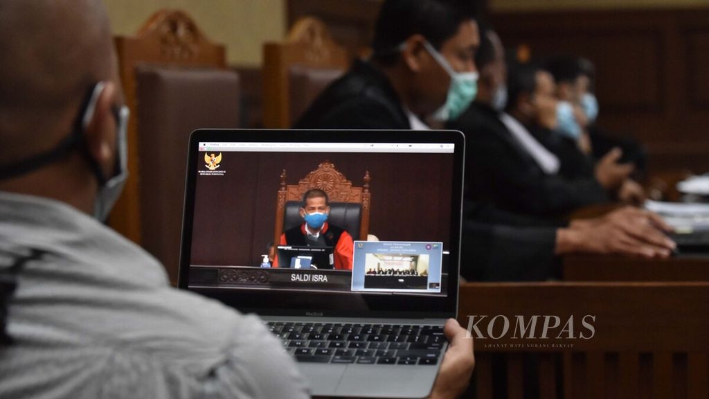 Warga menyaksikan sidang virtual uji materi terhadap Undang-Undang (UU) Nomor 11 Tahun 2020 tentang Cipta Kerja yang diajukan oleh Konfederasi Serikat Pekerja Indonesia (KSPI) di Mahkamah Konstitusi, Jakarta, Selasa (24/11/2020). 
