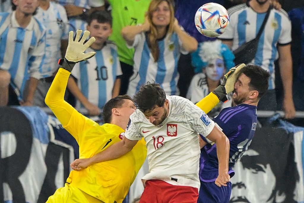 Penyerang Argentina, Lionel Messi, berbenturan dengan penjaga gawang Polandia, Wojciech Szczesny, saat laga Grup C Piala Dunia 2022 antara Polandia dan Argentina di Stadion 974, Doha, Qatar, Kamis (1/12/2022) dini hari WIB. 