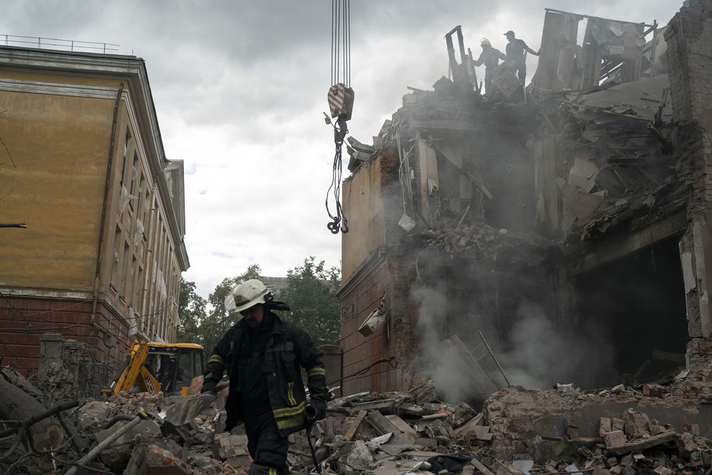 Petugas Pemadam Kebakaran bekerja untuk memadamkan api dan mencari korban yang diduga masih hidup diantara retuntuhan bangunan apartemen di Slovianks, Ukraina, Rabu (7/9/2022). 