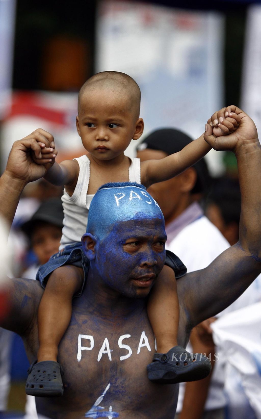 Simpatisan Partai Amanat Nasional (PAN) mengecat muka dan badannya dengan warna biru sembari menggendong anaknya untuk meramaikan kampanye partai itu di Lapangan Blok S, Jakarta, Selasa (31/3/2009). Kampanye tersebut menghadirkan juru kampanye Ketua Umum PAN Soetrisno Bachir. 