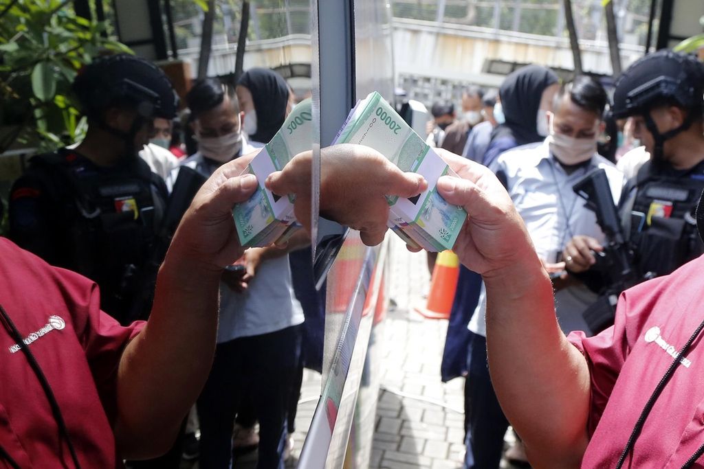 Karyawan Kompas Gramedia menukarkan uangnya dengan uang rupiah kertas tahun emisi 2022 di Palmerah, Jakarta.