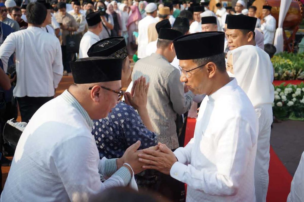 Penjabat Gubernur DKI Jakarta Heru Budi Hartono bersalam-salaman seusai melaksanakan shalat Idul Fitri 2023 di halaman Balai Kota DKI Jakarta, Sabtu (22/4/2023).