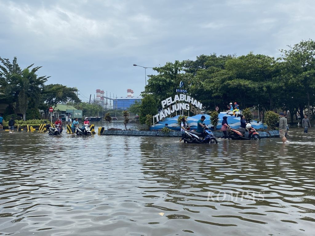 Para pekerja mendorong kendaraannya keluar dari kawasan Pelabuhan Tanjung Emas, Kota Semarang, Jawa Tengah, Rabu (26/5/2022). Ribuan kendaraan para pekerja di kawasan itu terendam banjir rob selama beberapa hari lantaran ditinggal pemiliknya menyelamatkan diri saat tanggul laut di kawasan itu jebol pada Senin (23/5/2022). Kendaraan-kendaraan itu langsung dibawa ke bengkel untuk diperbaiki setelah terendam banjir rob setinggi 1,5 meter.