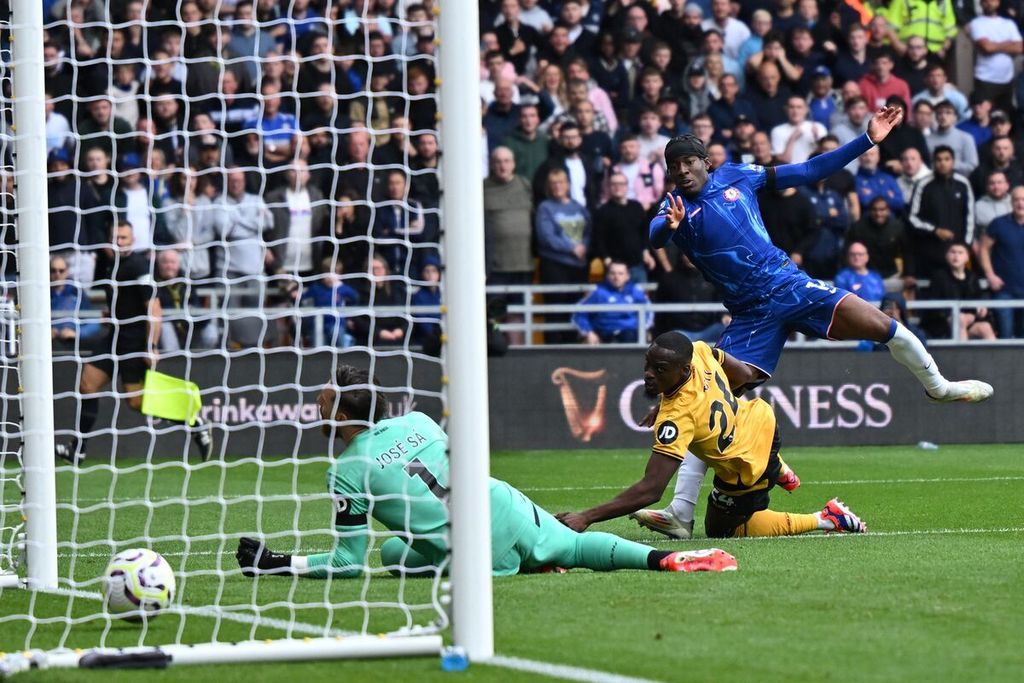 Pemain Chelsea, Noni Madueke (kanan), mencetak gol ke gawang Wolverhampton Wanderers pada laga Liga Inggris di Wolverhampton, Minggu (25/8/2024). 