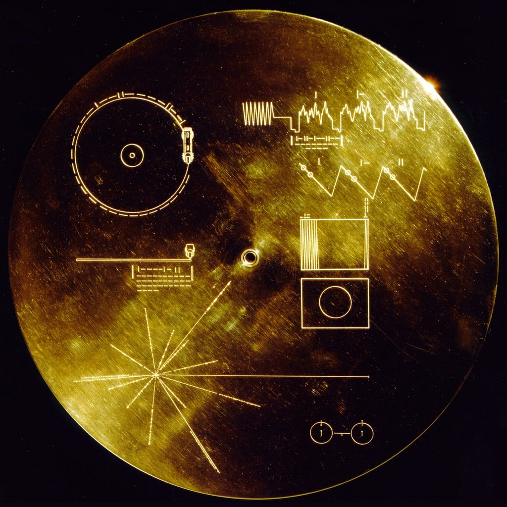 Keping cakram emas yang dibawa oleh wahana Voyager I dan Voyager II. Gambar garis-garis yang memancar dari satu titik di kiri bawah itu menunjukkan pulsar.