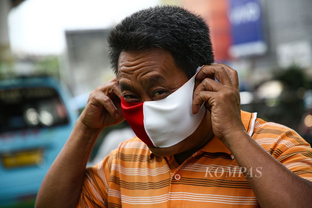 Warga yang terjaring operasi yustisi pencegahan Covid-19 di sekitar pasar Ciputat, Tangerang Selatan, Banten, mengenakan masker yang dibagikan personel kepolisian dan TNI, Minggu (25/10/2020). 
