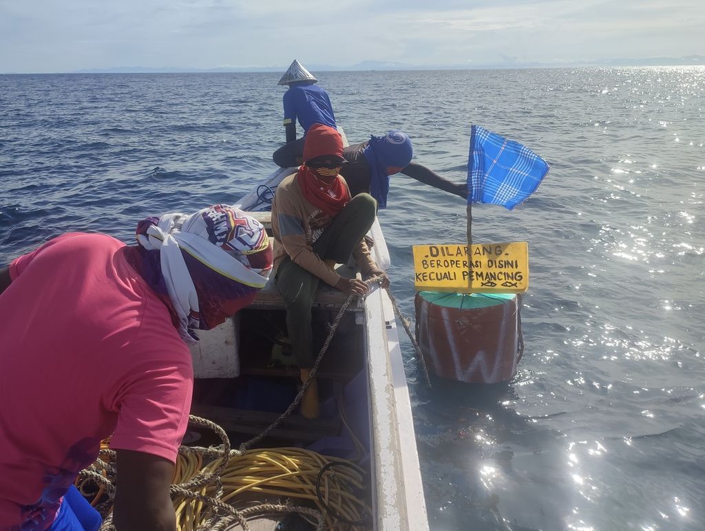 Nelayan memasang penanda dan papan bicara di kawasan yang ditetapkan sebagai area dilarang menangkap gurita, awal 2022 lalu. 