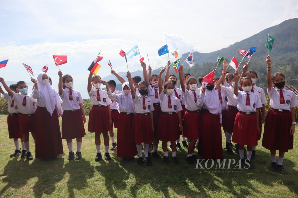 Para pelajar SD membawa bendera dari sejumlah negara dalam pembukaan W20 di Parapat, Simalungun, Sumut, Selasa, (19/7/2022).