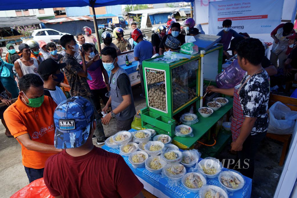 Warga mengantri pembagian makanan di Posko Hidayatullah, di Mamuju, Sulawesi Barat, Jumat (29/1/2021). Puluhan ribu warga Mamuju masih berada di pengungsian setelah gempa melanda wilayah ini dua pekan lalu.