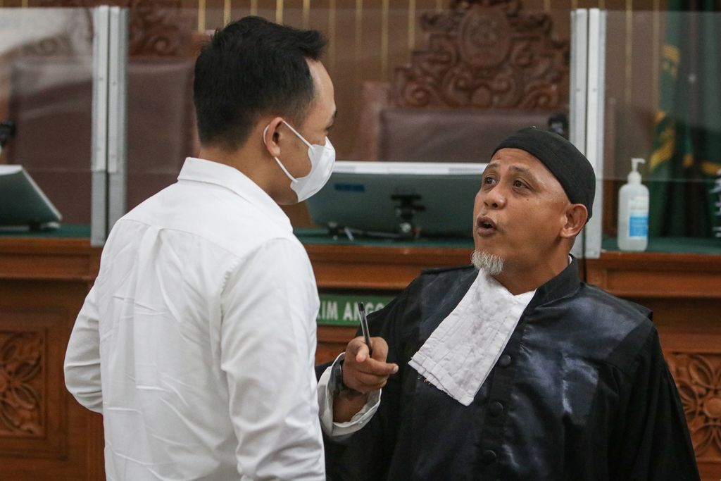 Defendant Ricky Rizal (left) talks with his lawyer after a hearing at the South Jakarta District Court, Monday (16/1/2023).
