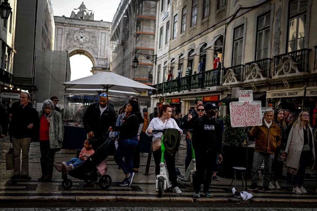 Seorang perempuan dengan membawa skuter menanti kesempatan untuk menyeberang jalan di Lisabon, Portugal, 15 Februari 2023. Laporan Organisasi Kesehatan Dunia (WHO) serta Organisasi Kerja Sama Pembangunan dan Ekonomi (OECD) mengungkap warga Portugal sebagai warga paling malas berolahraga di Eropa. 