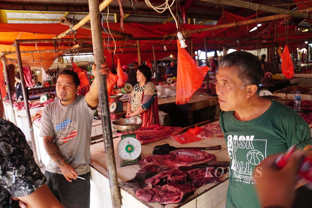 Marlon Supit (kiri) dan Atoks berbincang tentang pelarangan penjualan daging anjing dan kucing di Pasar Beriman Wilken, Tomohon, Sulawesi Utara, pada Selasa (25/7/2023). 