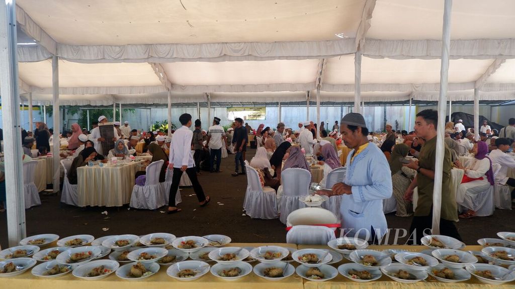 Warga mengambil makanan dalam acara makan bersama rakyat yang digelar di area rumah dinas Gubernur Kalimantan Selatan Sahbirin Noor di Banjarmasin seusai pelaksanaan shalat Idul Fitri 1444 Hijriah, Sabtu (22/4/2023). 