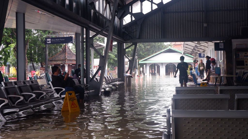 Calon penumpang menunggu di Stasiun Semarang Tawang, Kota Semarang, Jawa Tengah, yang terendam banjir, Sabtu (6/2/2021). Dengan kedalaman tertinggi 1 meter di titik terdalam, stasiun tersebut untuk sementara tak beroperasi. Ada tujuh kereta api penumpang dan lima KA barang yang terdampak.