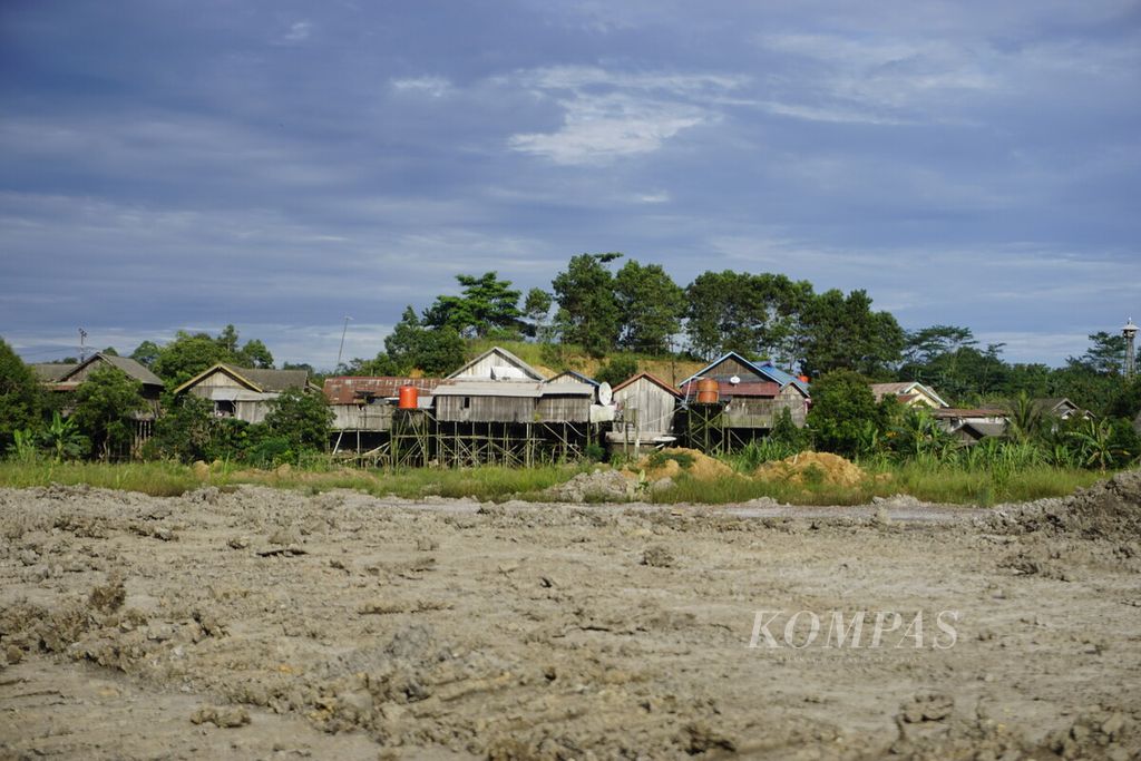 Rumah-rumah warga berjejer sekitar 300 meter dari bibir lubang tambang batubara di Desa Mulawarman, Kecamatan Tenggarong Seberang, Kalimantan Timur, Minggu (5/1/2019).