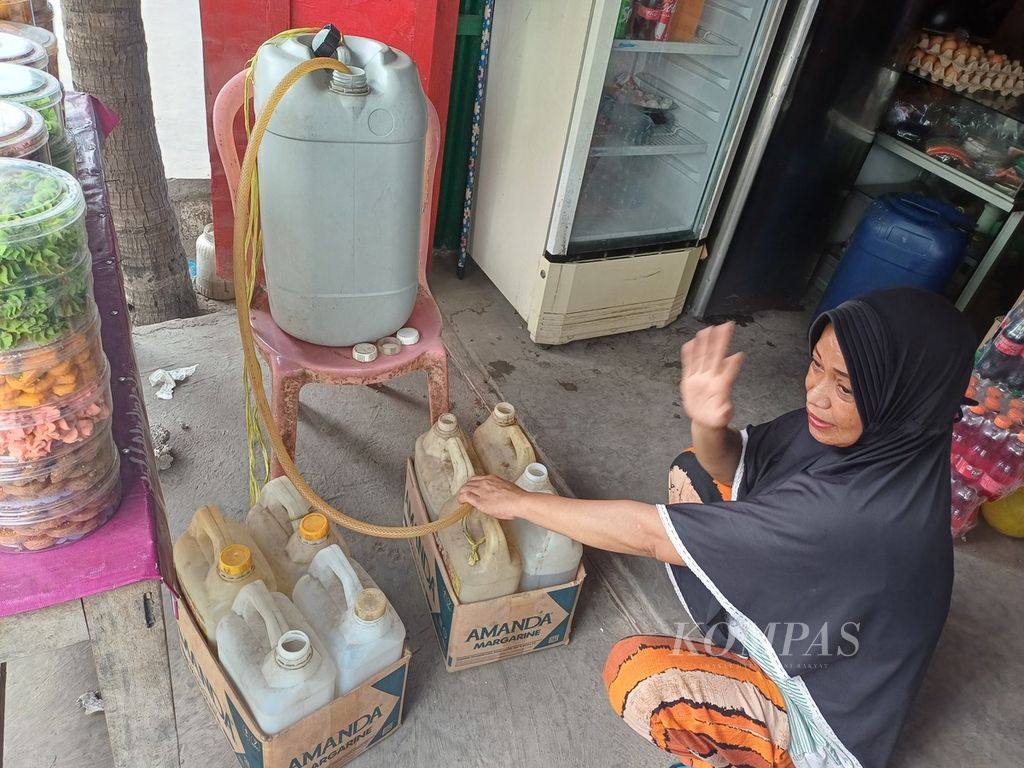 Ny Khadijah (43), pemilik kios Sejahtera di Kelurahan Oebufu, Kota Kupang, Nusa Tenggara Timur, Kamis (21/12/2023). Kios ini berjarak 5 meter dari agen minyak tanah UD Sriwijaya. Minyak tanah dalam jeriken 5 liter dijual kepada konsumen Rp 20.000 per jeriken. 