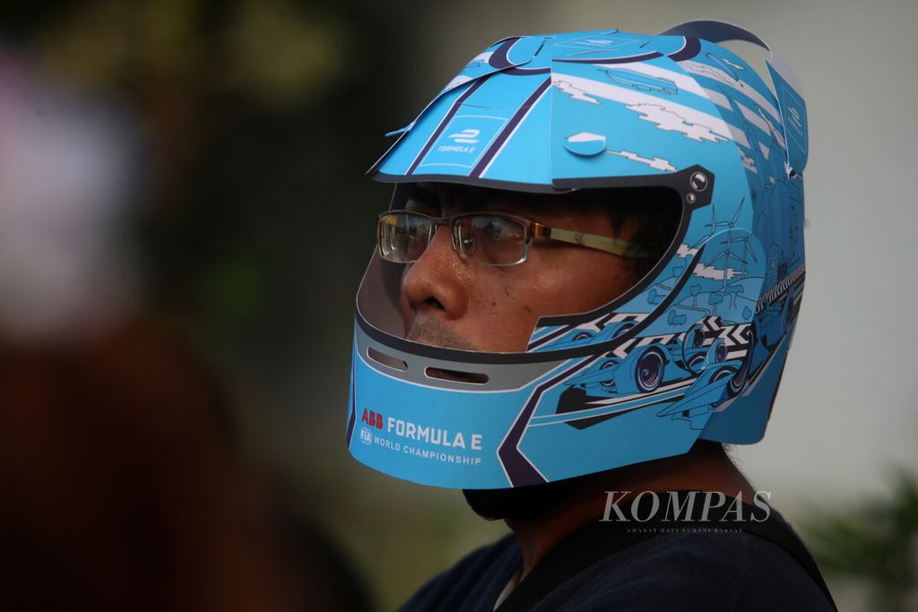 Penonton mengenakan hiasan helm dari kertas di sela-sela ajang balapan Formula E seri kesembilan di Jakarta International E-Prix Circuit (JIEC), Jakarta, Sabtu (4/6/2022). Pebalap Jaguar TCS Mitch Evans menjadi pemenang seusai menjadi yang tercepat menyelesaikan putaran 40 lap dengan catatan waktu 48 menit 28,424 detik, diikuti pembalap DS Techeetah Jean-Eric Vergne (48 menit 29,157 detik) dan pembalap Rokit Venturi Racing Edoardo Mortara (48 menit 29,391 detik).