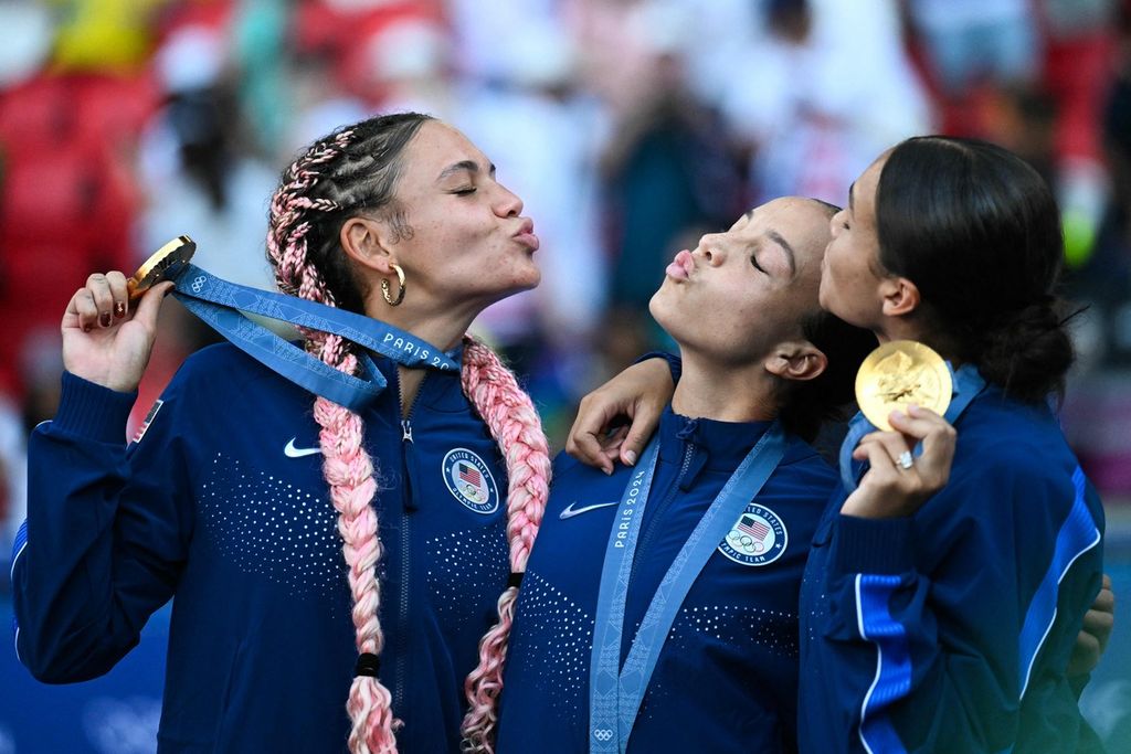 Trio penyerang Amerika Serikat, Trinity Rodman (kiri), Mallory Swanson (tengah), dan Sophia Smith, berpose dengan medali emas sepak bola putri Olimpiade Paris 2024 seusai mengalahkan Brasil, 1-0, pada laga final di Parc des Princes, Paris, Sabtu (10/8/2024). 