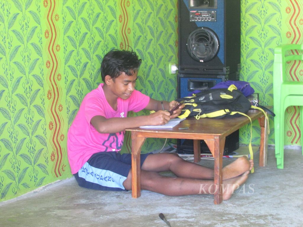 Aldi Lomi (14), siswa kelas II SMPN 27 Kota Kupang, sedang belajar daring di rumahnya di Kelurahan Kolhua Kupang, Nusa Tenggara Timur, Agustus 2020. 