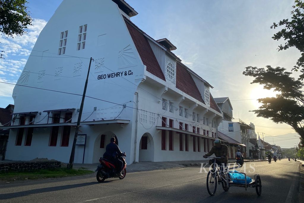 Seorang warga dengan sepeda pembawa barang melintas di depan Gedung Geo Wehry & CO di Kawasan Kota Tua Padang, Kota Padang, Sumatera Barat, Jumat (16/6/2023) pagi. Gedung tersebut adalah salah satu bangunan bersejarah peninggalan zaman kolonial Belanda dan saat ini menjadi bangunan cagar budaya yang dilindungi. 
