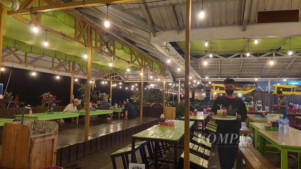 A waiter delivers drinks ordered by customers at Warung Jukung Julak, Banua Anyar Village, East Banjarmasin, Banjarmasin City, South Kalimantan, Saturday (22/1/2022). The food stall on the banks of the Martapura River is an option to enjoy culinary tourism in Banjarmasin.