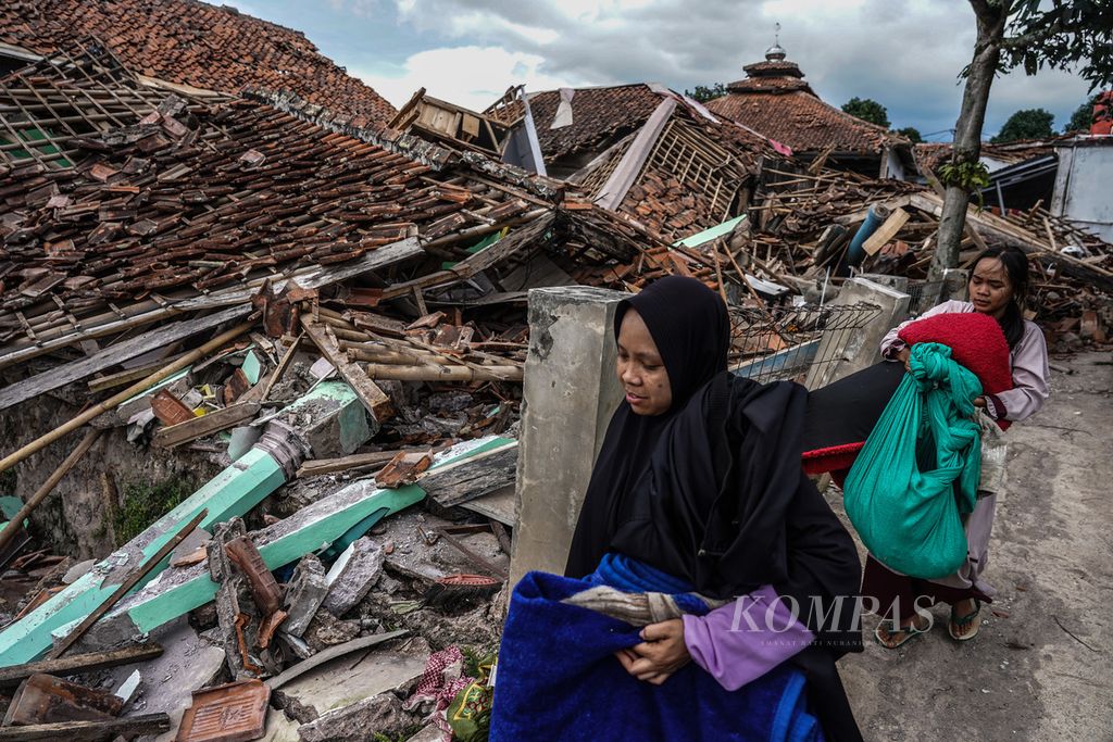 Warga membawa harta bendanya menuju pengungsian di Cugenang, Kabupaten Cianjur, Jawa Barat, Selasa (22/11/2022). Kondisi kerusakan akibat gempa yang melanda Cianjur pada Senin (22/11/2022) terlihat pada sejumlah wilayah desa yang terdampak.