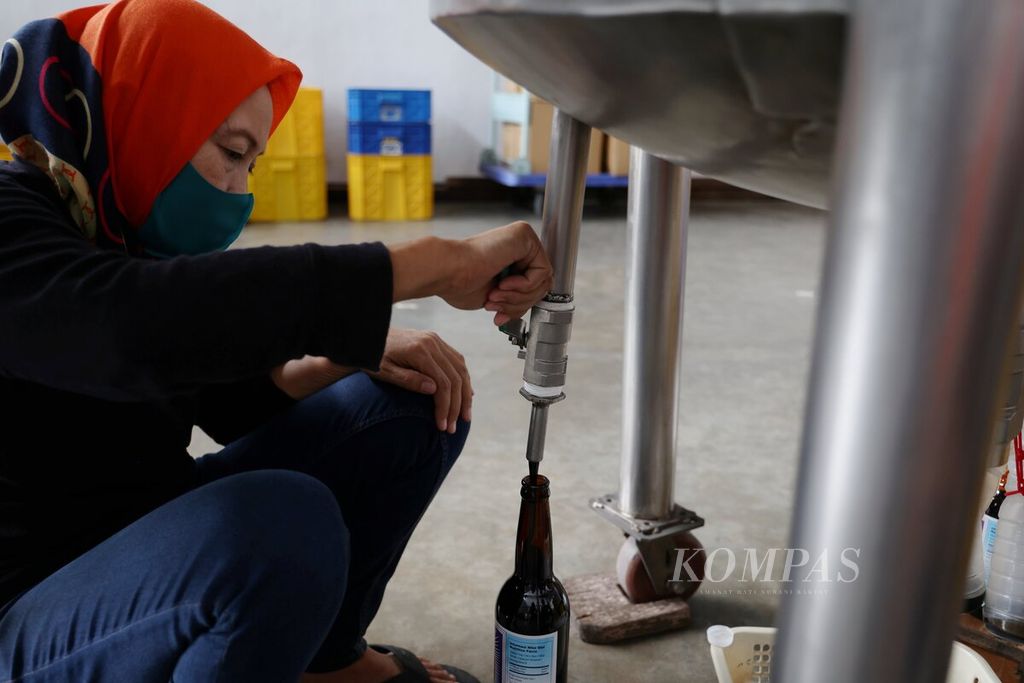 Pekerja mengemas kecap dalam botol kaca di pabrik kecap Karya Gemilang yang memproduksi kecap dengan jenama Kecap Cap Sapi di Jalan Holis, Kota Bandung, Jawa Barat, Rabu (14/6/2023). 