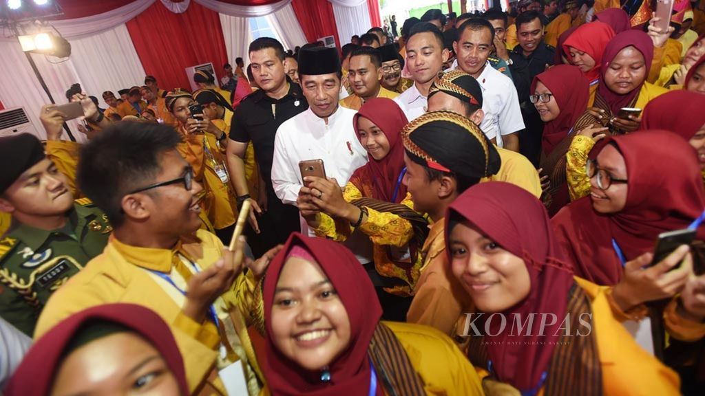 Peserta berebut berfoto bersama dengan Presiden Joko Widodo seusai pembukaan Muktamar XXI Ikatan Pelajar Muhammadiyah di Universitas Muhammadiyah Sidoarjo, Jawa Timur (19/11/2018). Presiden Jokowi berpesan kepada kaum muda untuk tanggap terhadap perkembangan teknologi.