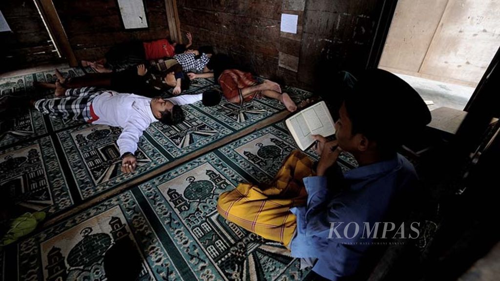 Santri mengisi waktu puasa mereka dengan beristirahat dan membaca Al Quran di mushala Pondok Pesantren Kauman.