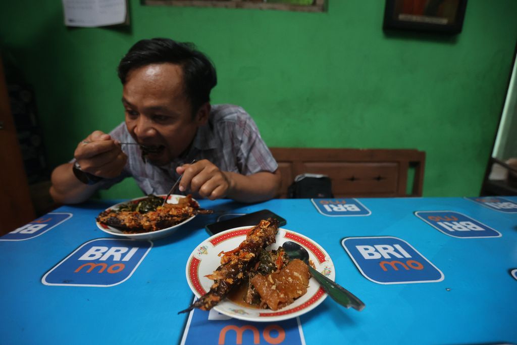 Pengunjung menyantap mangut lele di rumah makan Mangut Lele Dapur Asli Mbok Marto Ijoyo, Kecamatan Sewon, Kabupaten Bantul, Daerah Istimewa Yogyakarta, Rabu (21/9/2022). 