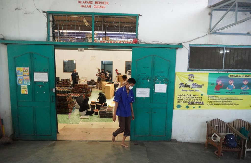 Perajin sarung tenun atau alat tenun bukan mesin (ATBM) sedang melintas di depan gudang produksi PT Asaputex, Kota Tegal, Jateng, Sabtu (4/4/2020). Para pekerja diimbau untuk melakukan tindakan pencegahan penyebaran Covid-19 sebelum masuk dan keluar pabrik.
