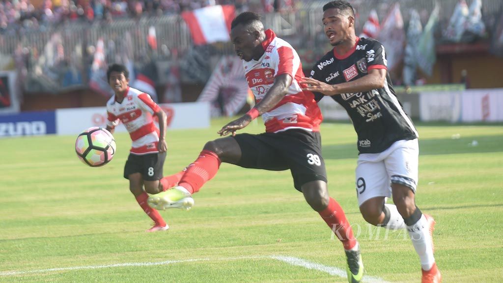 Pemain Madura United  FC Guy Junior Nke Ondoua  berusaha melewati Pemain Bali United FC Hasim Kipuw dalam Go-jek Taveloka Liga 1 di Stadion Gelora Ratu Pamelingan, Pamekasan, Minggu (16/4). Madura United menang 2-0.