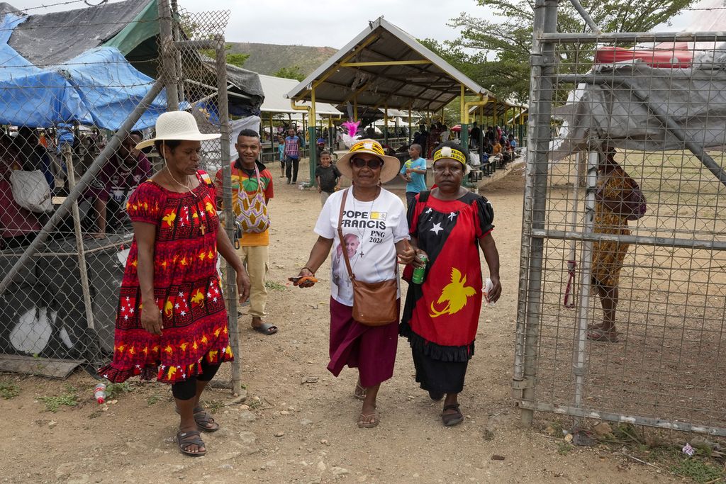 Seorang perempuan (tengah) mengenakan kaus bergambar Paus Fransiskus di sebuah pasar menjelang kunjungan Paus ke Port Moresby, Papua Niugini, Jumat (6/9/2024).