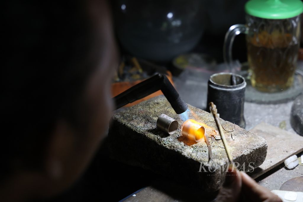 Pekerja menggarap kerajinan perak di bengkel kerajinan Unique Silver, Kampung Basen, Kelurahan Purbayan, Kotagede, Yogyakarta, Senin (1/4/2024).