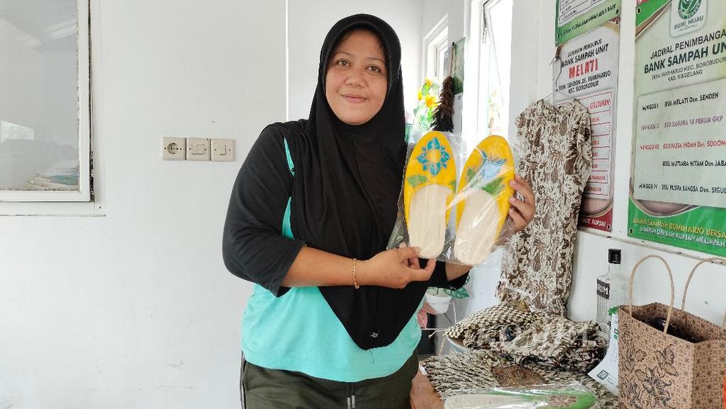 Hidayatul Rachmawati (47) menunjukkan salah satu produk kreatif buatan Bank Sampah Bumi Hijau, di Desa Bumiharjo, Kecamatan Borobudur, Kabupaten Magelang, Jawa Tengah, Rabu (14/12/2022). Sandal ini dibuat dari sandal bekas yang merupakan limbah dari salah satu hotel di Kecamatan Borobudur.