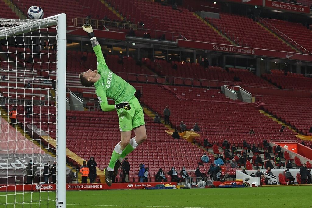 Kiper kesebelasan Everton, Jordan Pickford, mengetip bola tendangan pemain Liverpool dalam pertandingan Liga Primer Inggris di Stadion Anfield, 20 Februari 2021. <i>Mengetip</i> adalah salah satu bentuk turunan dari kata <i>tip</i>, yang berarti ’menyentuh bola dengan jari tangan (agar bola tidak masuk ke dalam gawang)’.